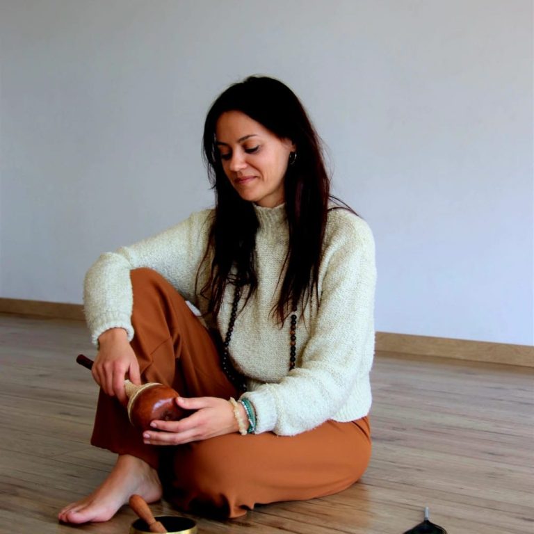 Conciencia de corazón Mujer sentada en el suelo, tocando un instrumento musical, con ropa cómoda y un ambiente tranquilo.
